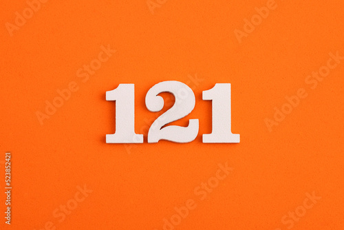 White wooden number 121 on eva rubber orange background