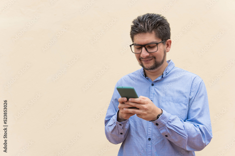 man typing on cell phone with yellow background man typing on cell phone with yellow background