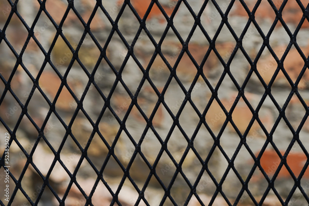 Mesh fence on stone background outdoors Mesh fence on stone background outdoors