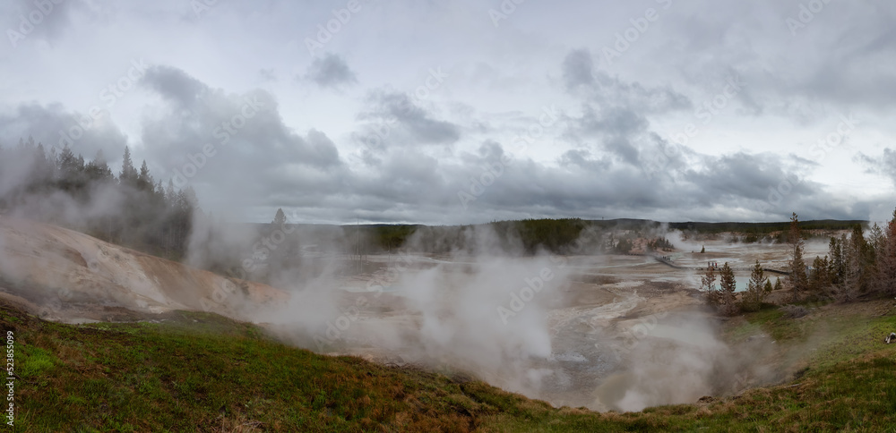 Hot spring Geyser with colorful water in American Landscape. Cloudy Sky. Yellowstone National Park, Wyoming, United States. Nature Background Panorama