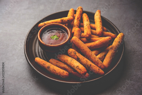 crispy Rava Aloo fingers or Potato semolina fried finger sticks served with ketchup photo