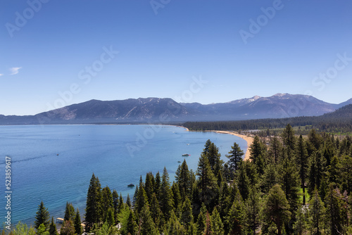 Large Lake with Beach surrounded by Trees and Mountains. Summer Season. Lake Tahoe, California, United States. Nature Background.