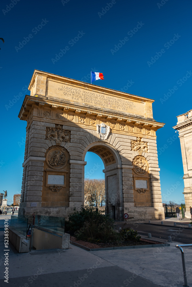 street and triumph arch in montpelier france with french flag