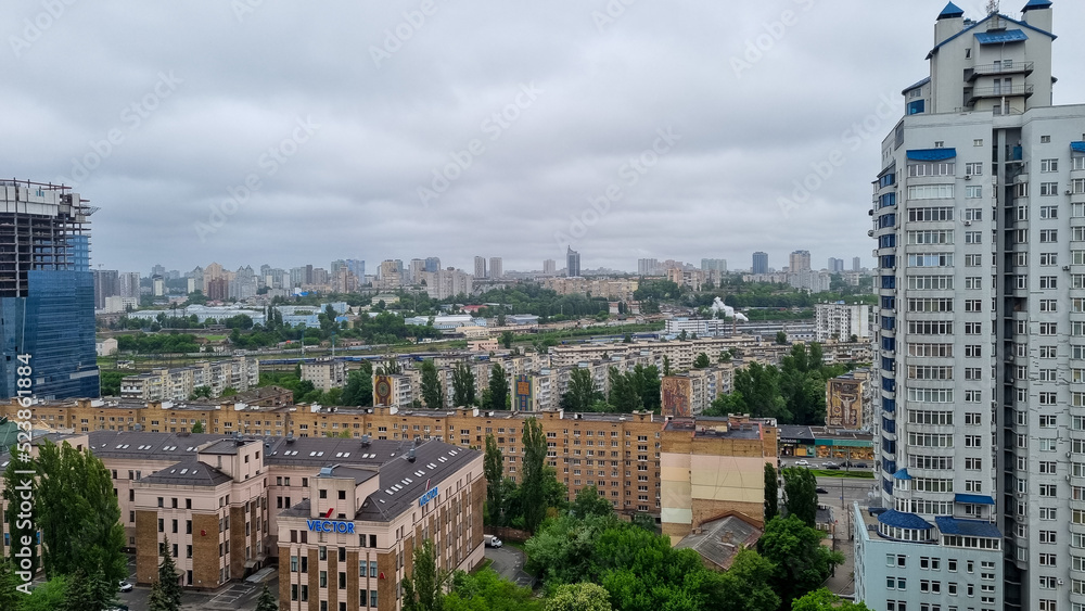 aerial view from the top floor on the urban city, town from the distance, grey cloudy sky, concrete jungle