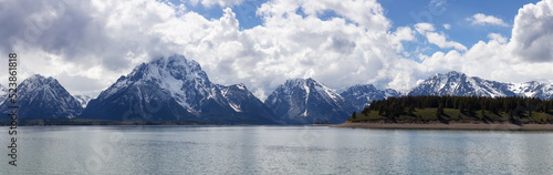 Rocky Beach by the Lake with Mountains in Background. Spring Season. Grand Teton National Park. Wyoming, United States. Nature Landscape Panorama