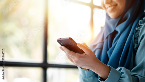 Asian women in hijab are using the mobile phone, administration and operations from the young, smart working women. The management concept drives the company of women leaders to grow.