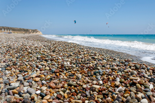 Sea beach with colorful wet pebbles and good wind for kitesurfing