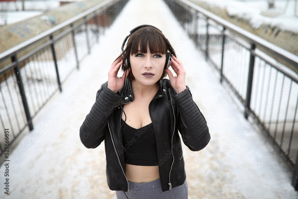 Girl in headphones listening to music outdoors