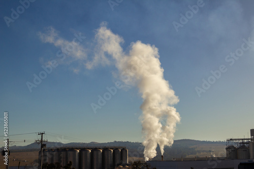 Fábrica emitindo fumaça no meio ambiente. © Angela