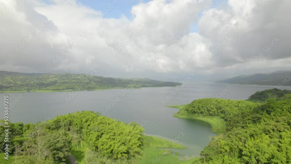 Toma aérea del lago del volcán arenal desde Tilarán con bosque y vegetación al rededor en un día soleado Toma aérea del lago del volcán arenal desde Tilarán con bosque y vegetación al rededor en un día soleado