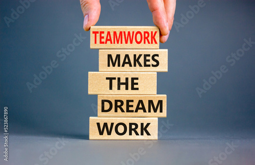 Teamwork makes dream work symbol. Concept words Teamwork makes the dream work on wooden blocks on a beautiful grey background. Businessman hand. Business Teamwork makes dream work concept. Copy space.