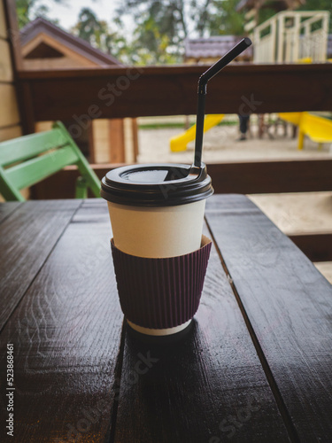Paper cup with coffee on the table. Street drink