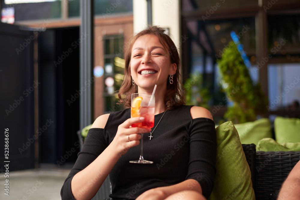 Image of a beautiful woman with a cocktail in her hand in a lounge bar. Vacation concept. Image of a beautiful woman with a cocktail in her hand in a lounge bar. Vacation concept.