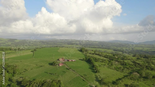 Toma aérea del parque eólico (eólicas) de Tilarán, las montañas de Tilarán y una lechería en Tilarán de Guanacaste Costa Rica  en el atardecer de un día soleado photo