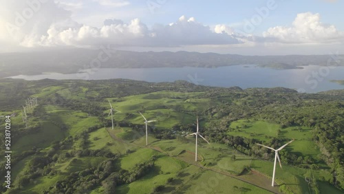 Toma aérea del parque eólico (eólicas) de Tilarán de Guanacaste Costa Rica con el lago Arenal de fondo en el atardecer de un día soleado photo