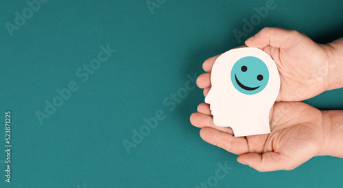 Foto Holding a head with a smiling face in the hands, mental health concept, positive