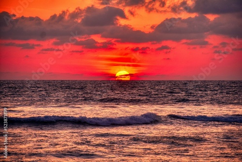 A setting sun reflects off of the ocean waves creating and yellow and colorful sunset sky . Peshawar 