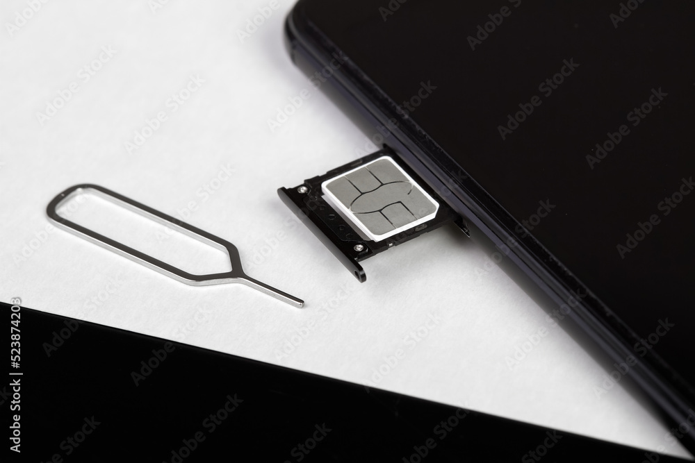 SIM card inserted into the sim card tray of a smartphone with pin needle tray remover SIM card inserted into the sim card tray of a smartphone with pin needle tray remover