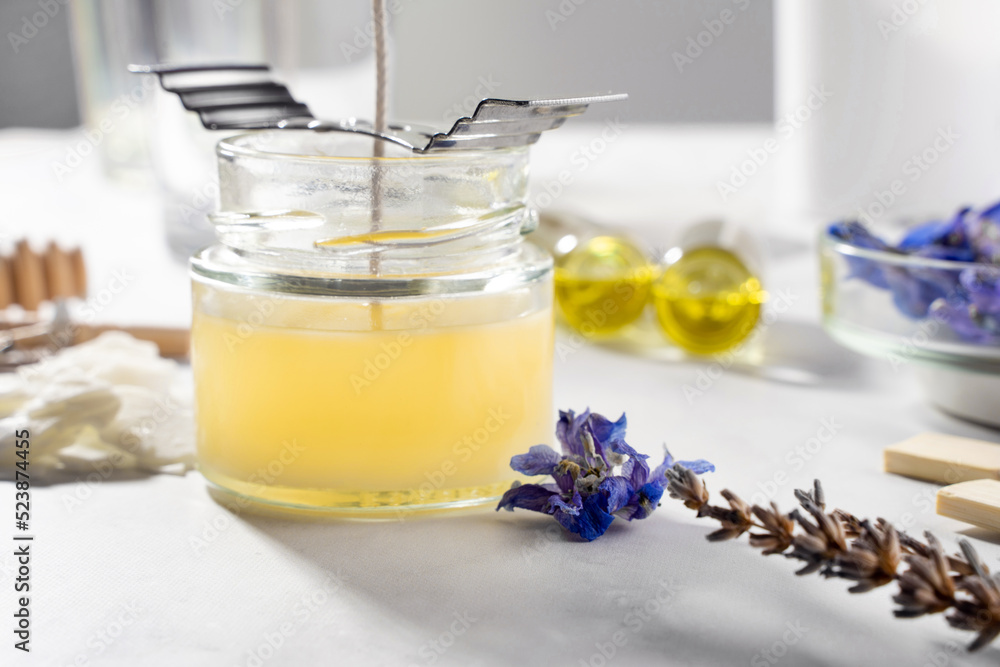 Set tools for homemade natural eco-friendly soy wax candles, wick, perfume, essential oil on a marble table. Making process. Trendy DIY. Craft hobby, small business, artisan products concept