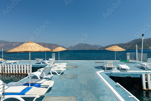 Marmaris, Turkey – Feeling of calmness on the pier going out to sea. with blue sky and rocky mountain Islands at background.