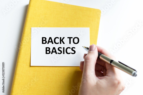 The businessman keeps a card with the text BACK TO BASICS.