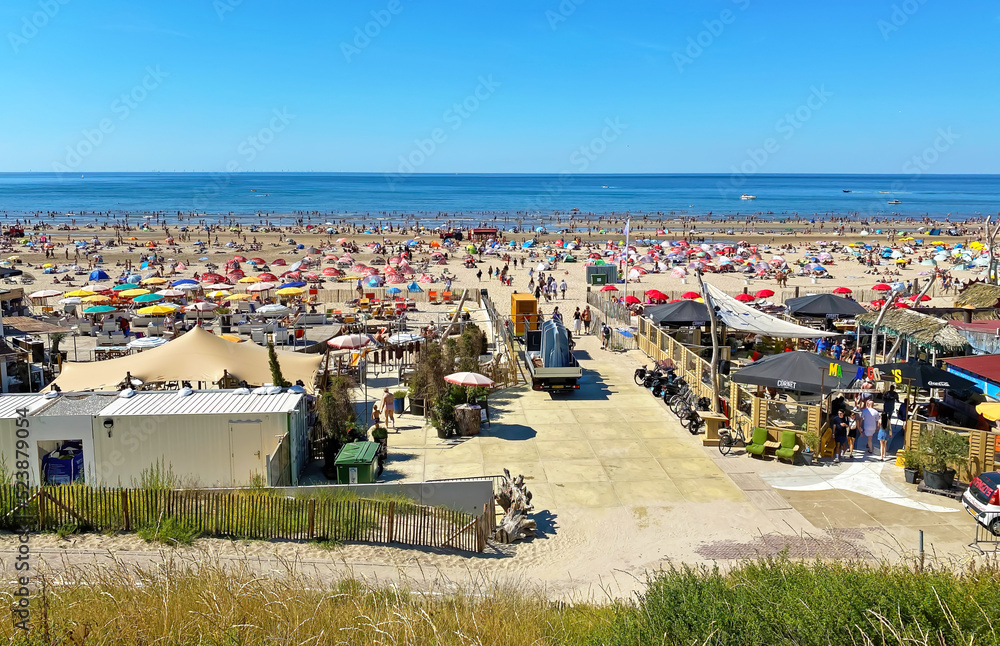 Zandvoort, Netherlands - August 12. 2022: View from dunes on crowded dutch north sea city beach on sunny summer weekend - obrazy, fototapety, plakaty 