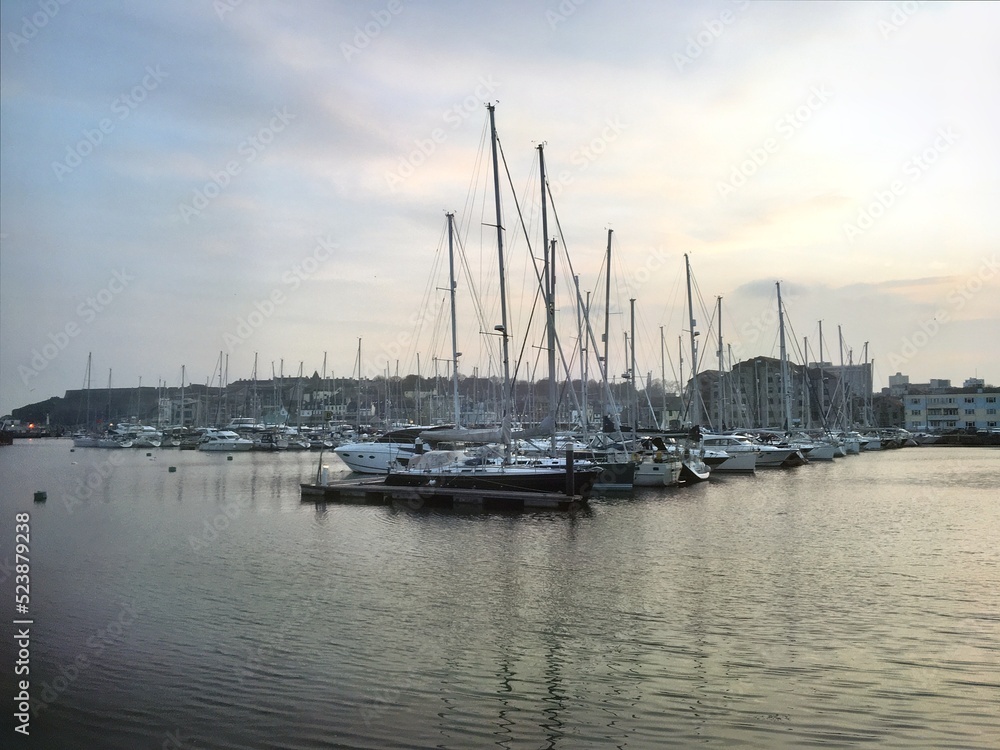 Harbour town with sailing yachts and motor boats by the sea on a sunset evening