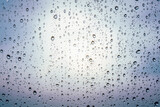 Raindrops on window glass, cloudy weather, background, texture.