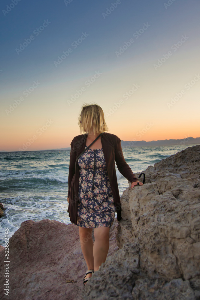 Kobieta w blasku zachodzącego słońca nad morzem śródziemnym