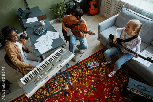 Canvas-taulu Top view at band of young musicians playing instruments together in cozy home st
