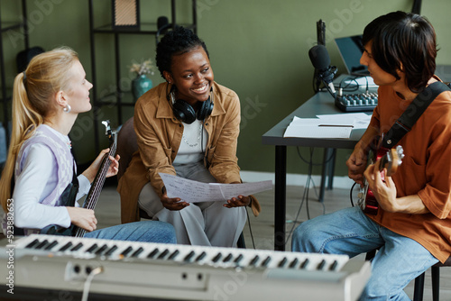Obraz na plátně Portrait of three young musicians writing songs together, focus on black woman s