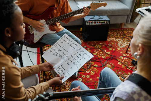 Fotografie Close up of black young woman writing songs with music band and holding lyrics s