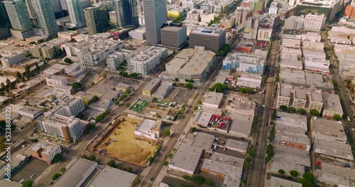 Approaching amazing skyscrapers in the financial downtown Los Angeles, California. Drone footage over the city panorama at backdrop of hills and blue skies.