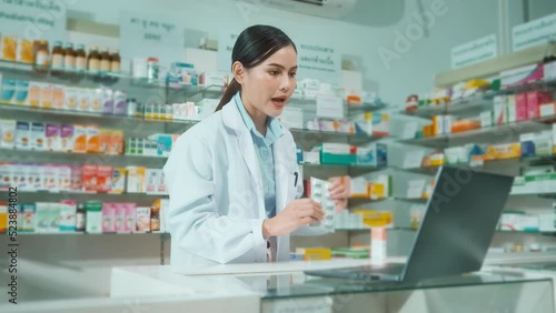 Female pharmacist counseling customer via video call in a modern pharmacy drugstore.