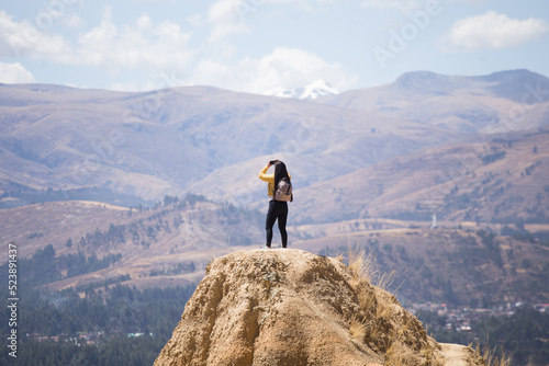 mujer turista disfrutando de sus vacaciones en lo más alto de una montaña con montañas al fondo. Concepto de viajes, turismo y estilos de vida.