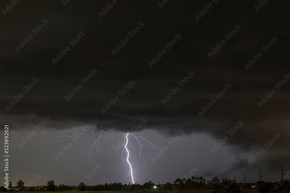 A summer storm with large lightnings over the Tuscan countryside of Bientina, Pisa, Italy