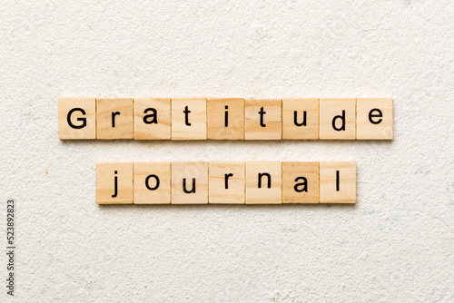Gratitude Journal word written on wood block. Gratitude Journal text on cement table for your desing, concept