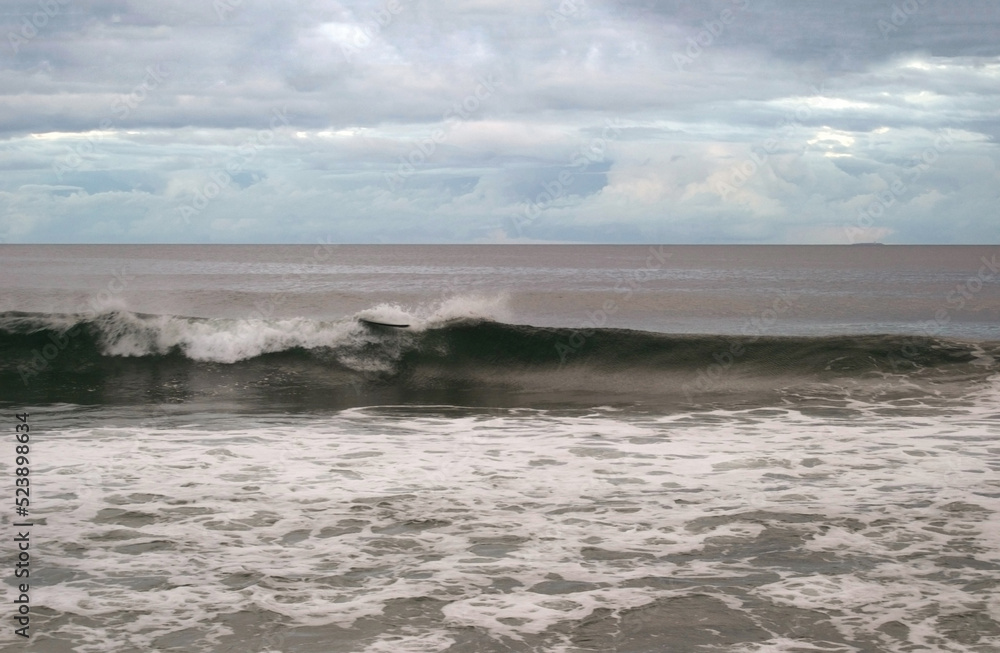 surfboard with no one on ocean wave 