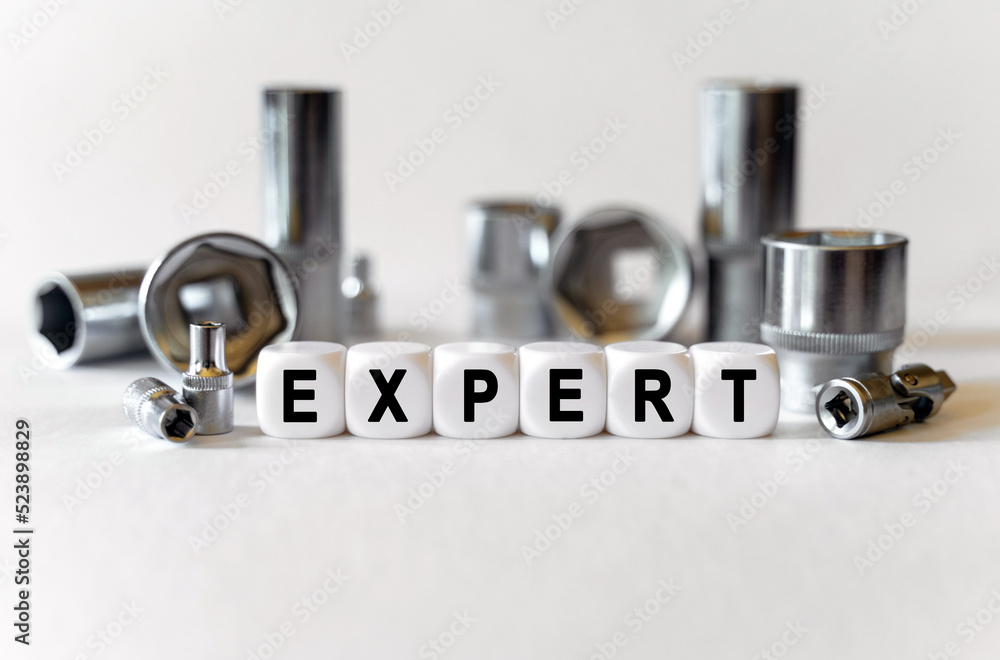 On a white background, a set with tools and white cubes with the inscription - Expert On a white background, a set with tools and white cubes with the inscription - Expert