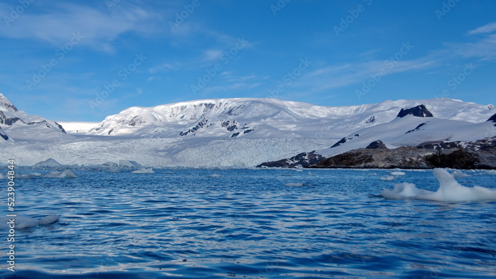 Icebergs floating at the base of snow covered mountains in Cierva Cove, Antarctica Icebergs floating at the base of snow covered mountains in Cierva Cove, Antarctica