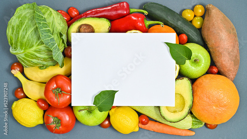 Creative copy space with paper and healthy fruits and vegetables on grey background. Healthy lifestyle concept. Flat lay