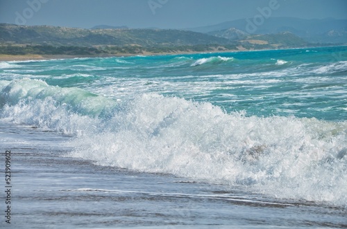 Aerial view of sea waves breaking beach in background of greenery hills photo