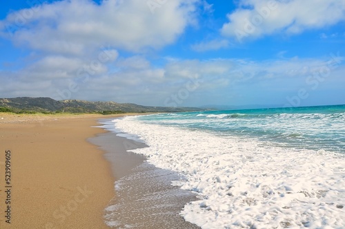 Aerial view of sea waves breaking beach in background of greenery hills photo