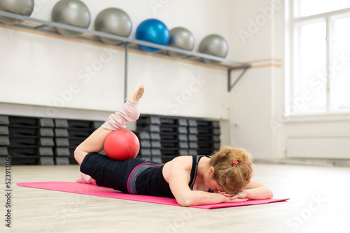 Middle aged woman doing pilates and yoga exercise in the sports gym