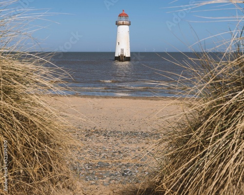 Point of Ayr Lighthouse in Wales visible from the dry grass area photo