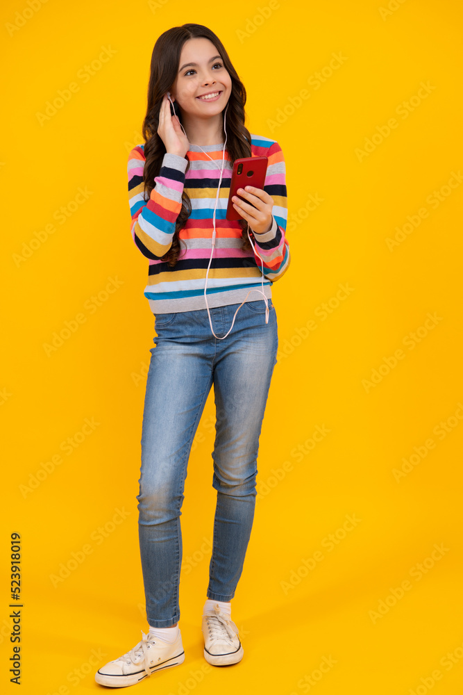 Teenager child girl holding smartphone. Hipster girl with cell phone. Kid hold mobile phone texting in online social networks. Happy teenager, positive and smiling emotions of teen girl. Teenager child girl holding smartphone. Hipster girl with cell phone. Kid hold mobile phone texting in online social networks. Happy teenager, positive and smiling emotions of teen girl.