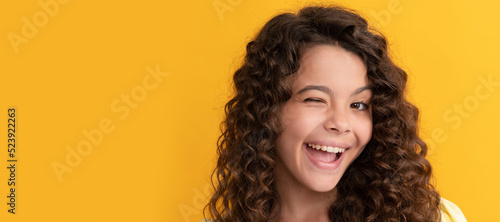 happy winking teen girl with long curly hair and perfect skin, frizzy. Child face, horizontal poster, teenager girl isolated portrait, banner with copy space.