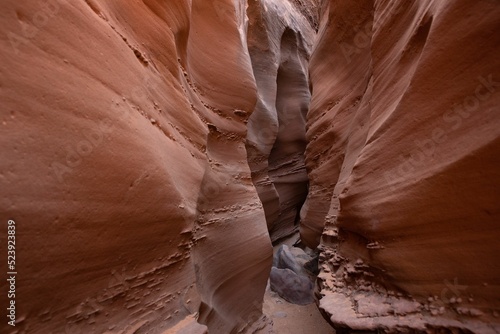 Canvas Print Closeup shot of a brown sandy cave with narrow passageway and abstract uneven wa