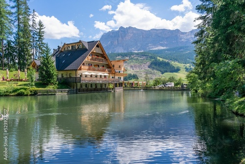 Beautiful Sompunt Lake with a small house and mountains in the background in Alta Val Badia, Italy photo