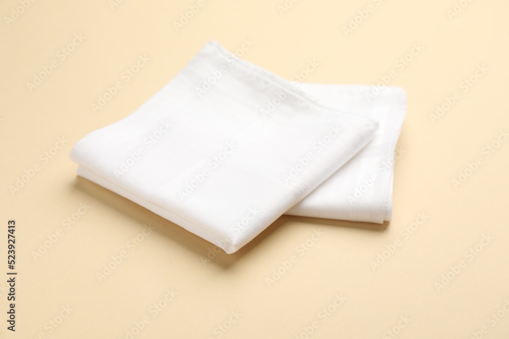 White handkerchiefs on beige background. Stylish accessory White handkerchiefs on beige background. Stylish accessory